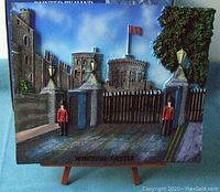 Front view of the hand painted 3-D decorative picture of Windsor Castle showing castle detail, guards in front gate, tree, and easel.