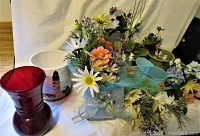 Overview of various flower pots, vases, and artificial flowers including red glass vase and white ceramic pot