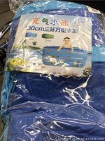 Blue inflatable kiddie pool in packaging showing printed ocean animal graphics and child image