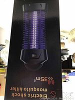 Photo of the boxed electric shock mosquito killer with on/off switch visible and promotional text on packaging.