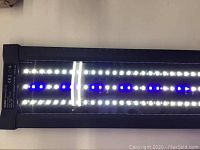 Close-up image showing NICREW Classic LED G2 light face with white and blue LEDs lit under transparent cover.