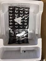 Rolled flexible keyboard placed in protective foam packaging showing numbers on keys.