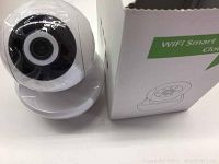 White NEYE branded dome security camera next to its box showing front lens with plastic wrapping.