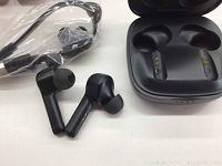 Pair of black Boltune Bluetooth earbuds next to charging case and accessories still in plastic.
