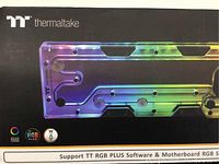 Box front showing the clear acrylic distro plate with rainbow RGB lighting and branding logos including TT RGB Plus and Razer Chroma.