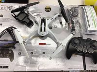 Overhead view of Sky Viper Journey GPS drone and all accessories laid out on branded box