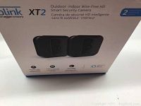 Box showing Blink XT2 branding and key features of outdoor/indoor wire-free HD smart security cameras, with 2-year battery life icon visible.