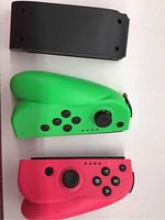 Top-down view of neon green and neon pink Nintendo Switch Joy-Con controllers with part of sliding rail system visible