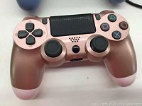 Rose pink DualShock 4 controller showing front view with buttons and touchpad.
