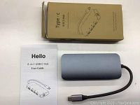 Type-C 8-in-1 hub showing aluminum body, user guide and box