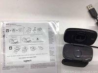 Logitech B525 HD Webcam foldable model with USB plug and instruction sheet in bag