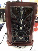 Front view of the S.O.S.L art deco style radio cassette player showing speaker grille and control knobs.