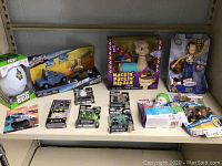 Shelf with variety of packaged toys including dinosaur egg, Fast & Furious car, Hackin' Packin' Alpaca, Woody from Toy Story, Batman figure, Call of Duty mini action figures, Fisher Price microphone, and others.