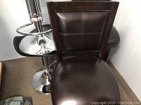 Front view of one brown wooden dining chair with dark brown cushioned seat and back, showing upholstery and wood frame