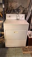 Front view of white freestanding dryer in basement