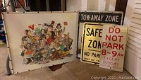 Group shot showing framed Rick Meyerowitz caricature print alongside three Dept of Traffic street signs leaning against wall