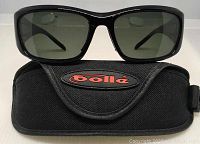 Front view of Bolle Origin 11012 sunglasses resting on the Bolle branded fasten Velcro case.