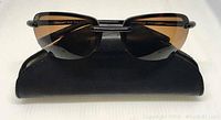 Front view of Serengeti Cirro sunglasses folded on black case showing tortoise frame and driver lenses.