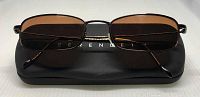 Front view of Serengeti Kiska sunglasses resting on the black branded case showing rectangular amber bronze lenses and thin black titanium frame.