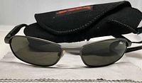 Front view of Bolle Mercuria 2.0 sunglasses with case and cleaning cloth beneath.