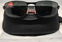 Front view of Bolle sunglasses on top of the Bolle branded case with cleaning cloth.