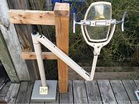 Full view of the vintage dental light mounted on a square base with the arm extended horizontally, showing the swivel head and adjustable arm assembly.