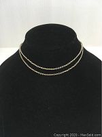 Front view of thin silver chain necklace on black display bust, showing the double layered chain link design and shiny silver finish.