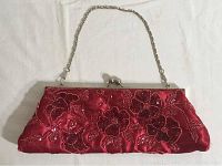 Front view of pink and red vintage evening clutch purse showing sequin beaded floral and leaf embroidery and silver chain strap attached to metal frame clasp