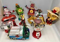 Wide view showing full group of 10 Christmas tree ornaments including robots, animals, vehicles, and festive characters.