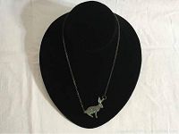 Full view of the necklace displayed on black stand showing the rabbit pendant and chain.