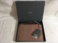 Ecco leather pouch in black box with tags, showing front face with logo and hang tag.