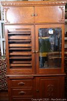 Full front view of cabinet showing doors, drawers and carved top molding