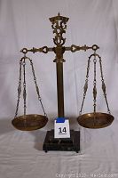Full front view of vintage apothecary scale showing brass beam, balance pans, and black marble base.