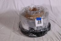 Photo of the Nuwave Pro Infrared Oven wrapped in plastic on a black base with 'Nuwave' branding visible.