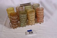 Full set of 8 iced tea glasses in metal carrier showing multiple glass colors and design.