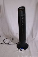 Full view of the black tower air purifier standing upright with power cord visible.