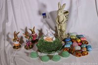 Large Easter-themed lot photo showing bunnies, decorative eggs, green cabbage bowl, small glass bowls.