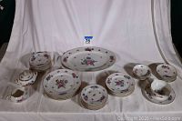 Entire Limoges Boulogne pattern china set displayed on white background showing platter, plates, saucers, cream, sugar, fruit cups and gravy boat.