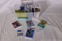 Clear plastic bin filled with numerous sealed hockey trading card packs, with some loose packs displayed in front including older wax paper wrapped types