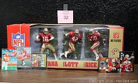 Full lot showing packaged McFarlane 3-pack San Francisco 49ers legends figurines with five vintage football trading cards in front.