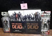 Two brand new sealed Walking Dead hardcover books six and seven with two action figures in original packaging: Merle Zombie and Andrea.