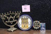Overall view of all four items: brass menorah with Star of David, Petra Jordan ceramic plate, Shalom key holder, and Shalom menorah patch in sealed package.