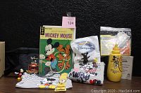 Full lot displayed including comic book, watch, figurine in bag, belt bag, mustard container, recipe cards, CDs, onesie, T-shirt