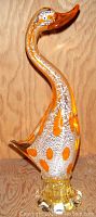 Front view of tall art glass duck figurine showing white and orange polka dot body with elongated neck and round clear base.