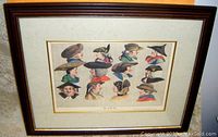 Frontal photo of the framed hand-coloured etching depicting various 18th-century hats.