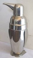 Full view of chrome penguin-shaped cocktail shaker showing front and side profile
