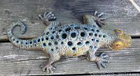 Top view of the enameled cast-iron lizard candleholder showing the round holes on the back and scaly texture.