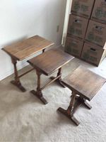 Set of three solid wood nesting tables arranged from largest to smallest showing overall condition and relative sizes.