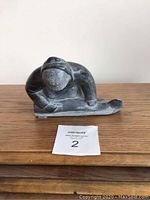 Front view of the stone carving showing the seated indigenous figure