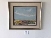 Framed landscape landscape painting mounted on wall.